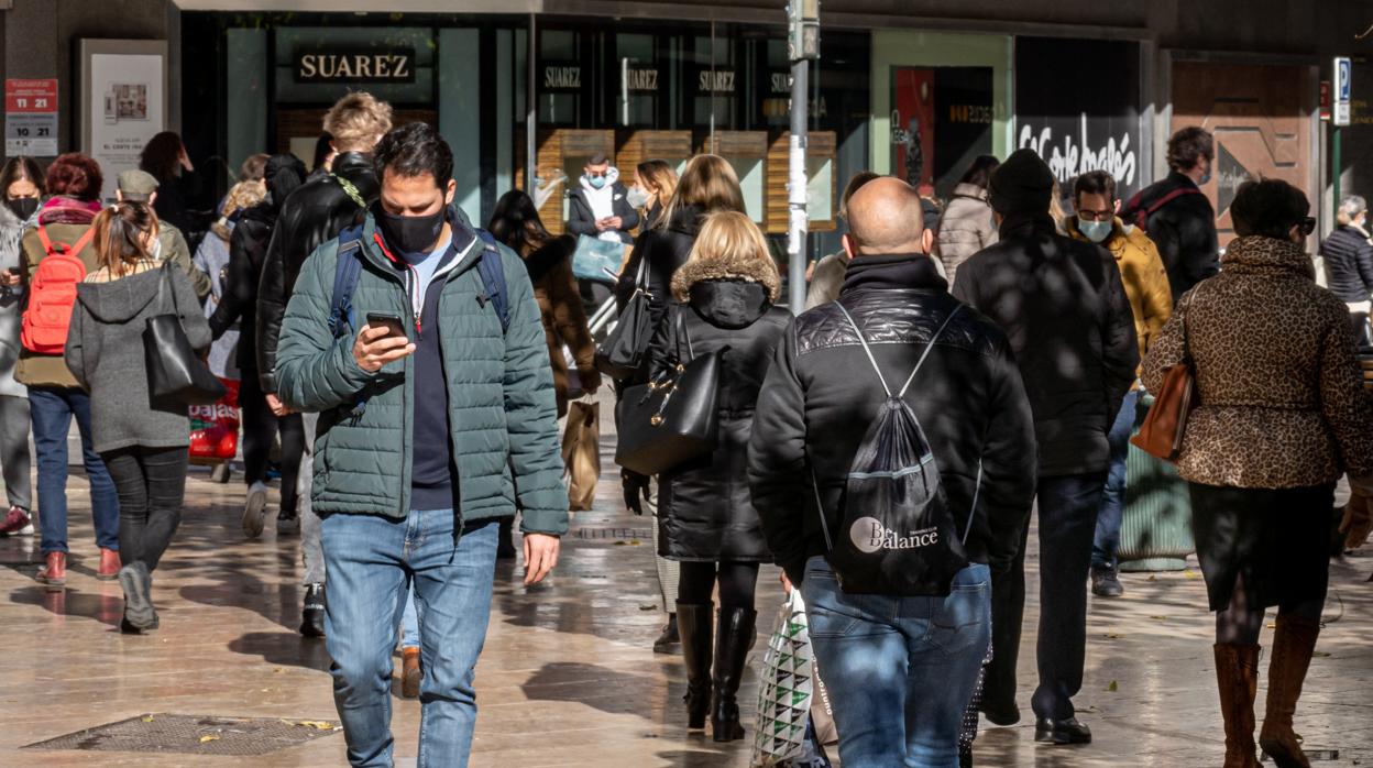 Imagen de personas con mascarilla por el coronavirus paseando por el centro de Valencia