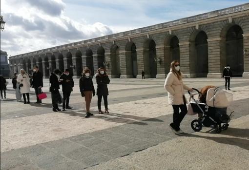 Varios visitantes hacen cola a las puertas del Palacio Real