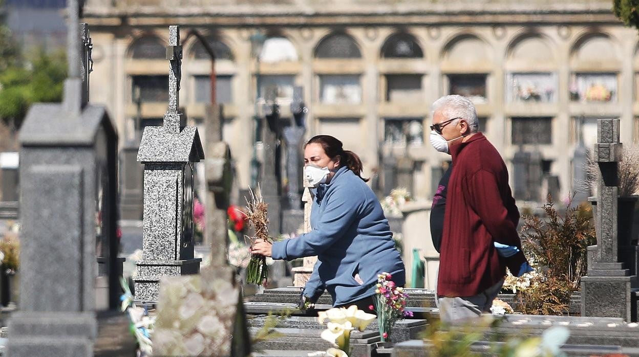 Familiares dejan flores en un cementerio gallego durante la primera ola del Covid