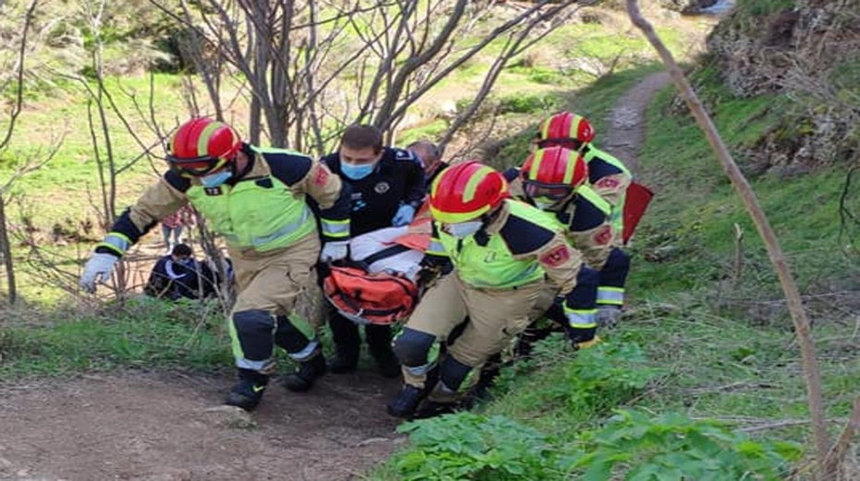 Los momberos trasladan a la mujer herida desde la zona de la caída