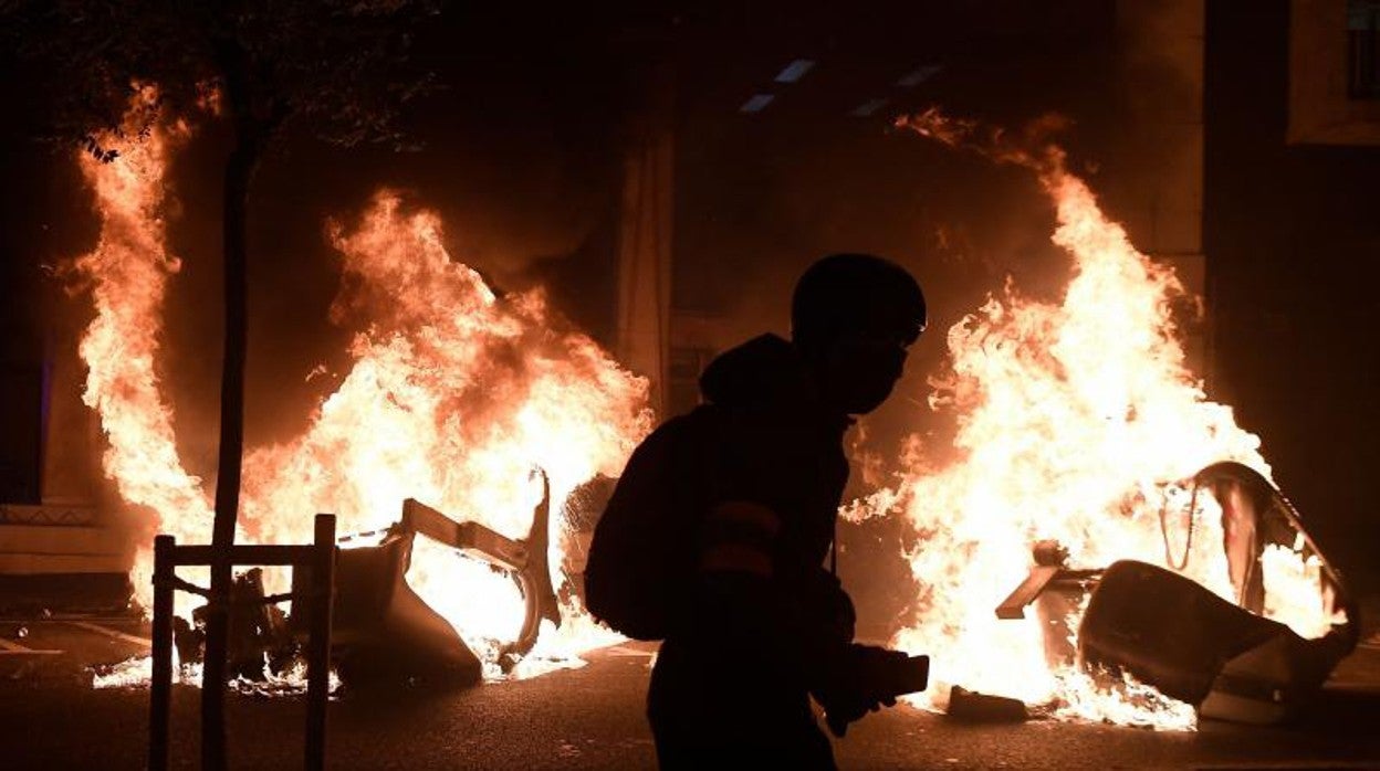 Un foto periodista ante una barricada, la noche del martes en Barcelona