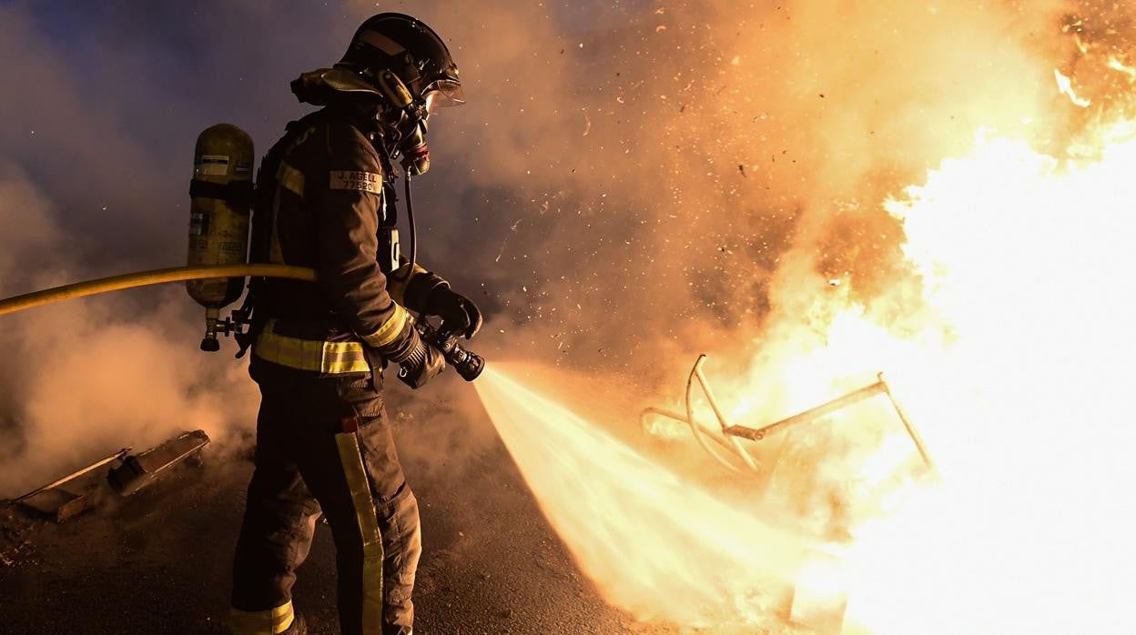 Un bombero apagando una barricada durante las protestas de esta semana