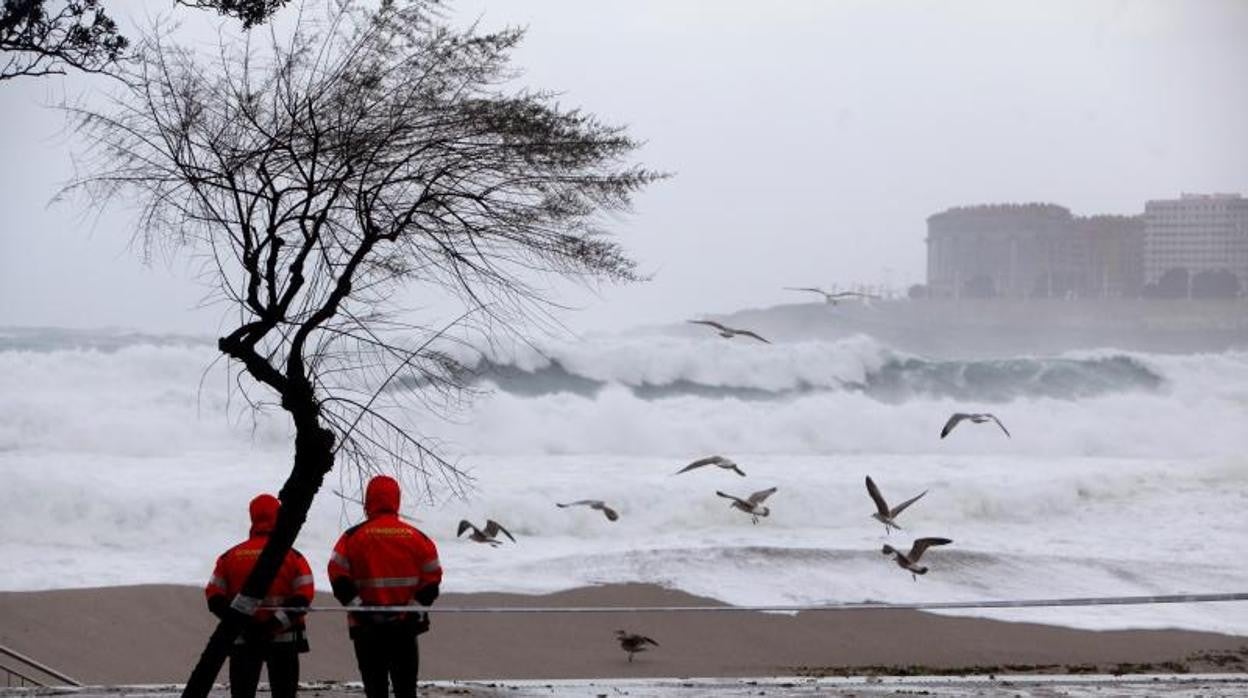 Dos bomberos mirando el temporal marítimo en una imagen de archivo