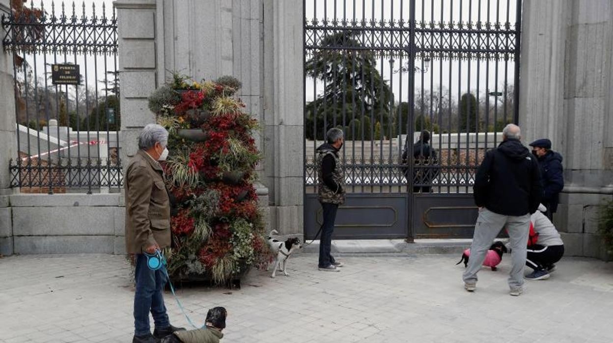 Varios ciudadanos con sus mascotas aguardan en la puerta a que El Retiro reabra tras 45 días cerrado por el azote de Filomena