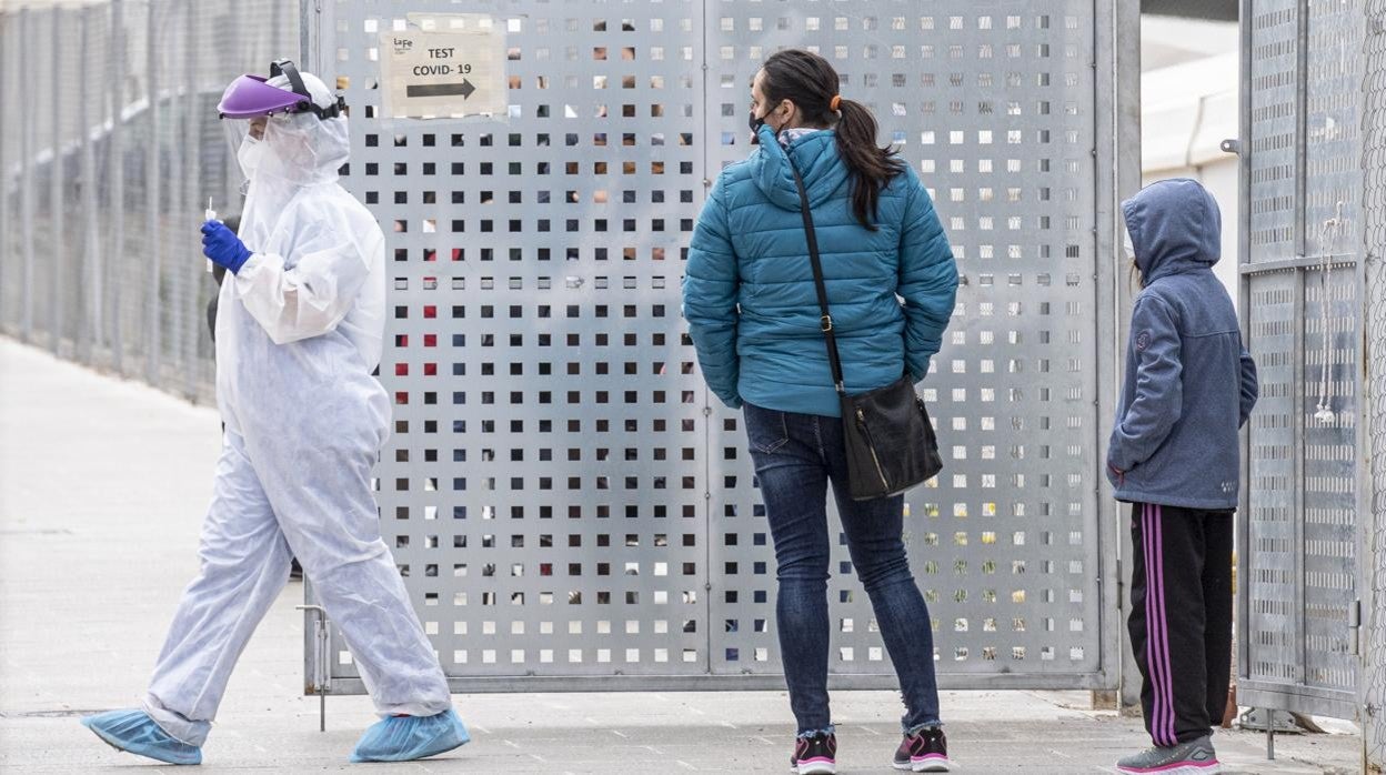 Imagen de un sanitario protegido contra el coronavirus realizando PCR en el exterior del hospital La Fe de Valencia