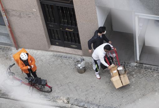 Un repartidor espera frente a la cocina industrial, mientras llegan ollas y otros utensilios de cocina