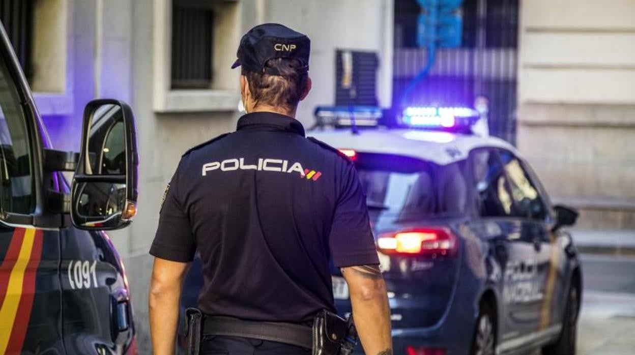 Un policía nacional junto a vehículos de patrulla