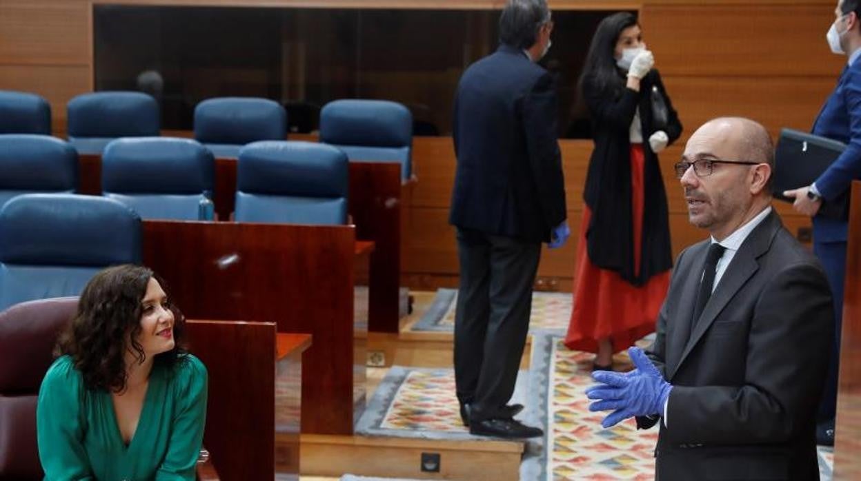 Juan Trinidad, presidente de la Asamblea de Madrid, charla con la presidenta Díaz Ayuso en la Asamblea madrileña