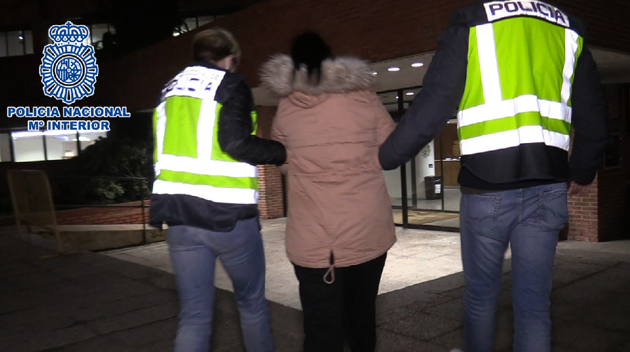 Una pareja de agentes conduce a una de las arrestadas a dependencias policiales