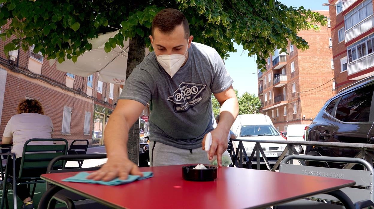 Un camarero limpia la mesa de una terraza en Valladolid