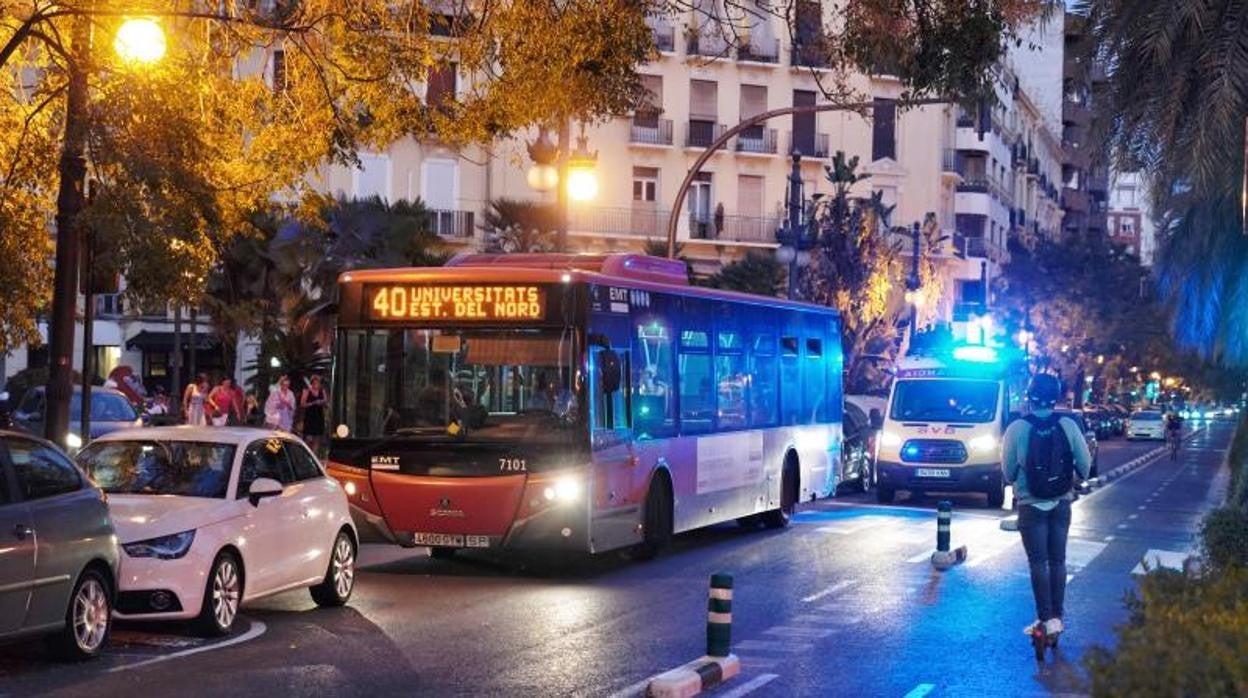 Un usuario de patinete pasa junto a un autobús urbano en Valencia, en imagen de archivo