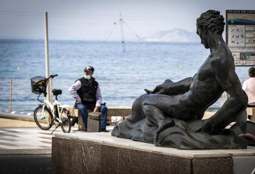 Un hombre descansa en el paseo de la playa de Levante