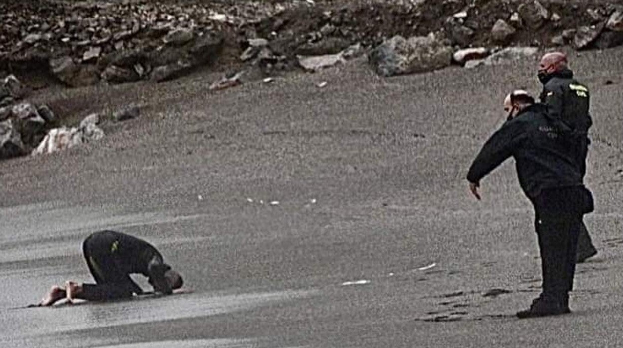 Un inmigrante marroquí besa la arena de la playa de Ceuta tras llegar a nado el domingo desde Castillejos