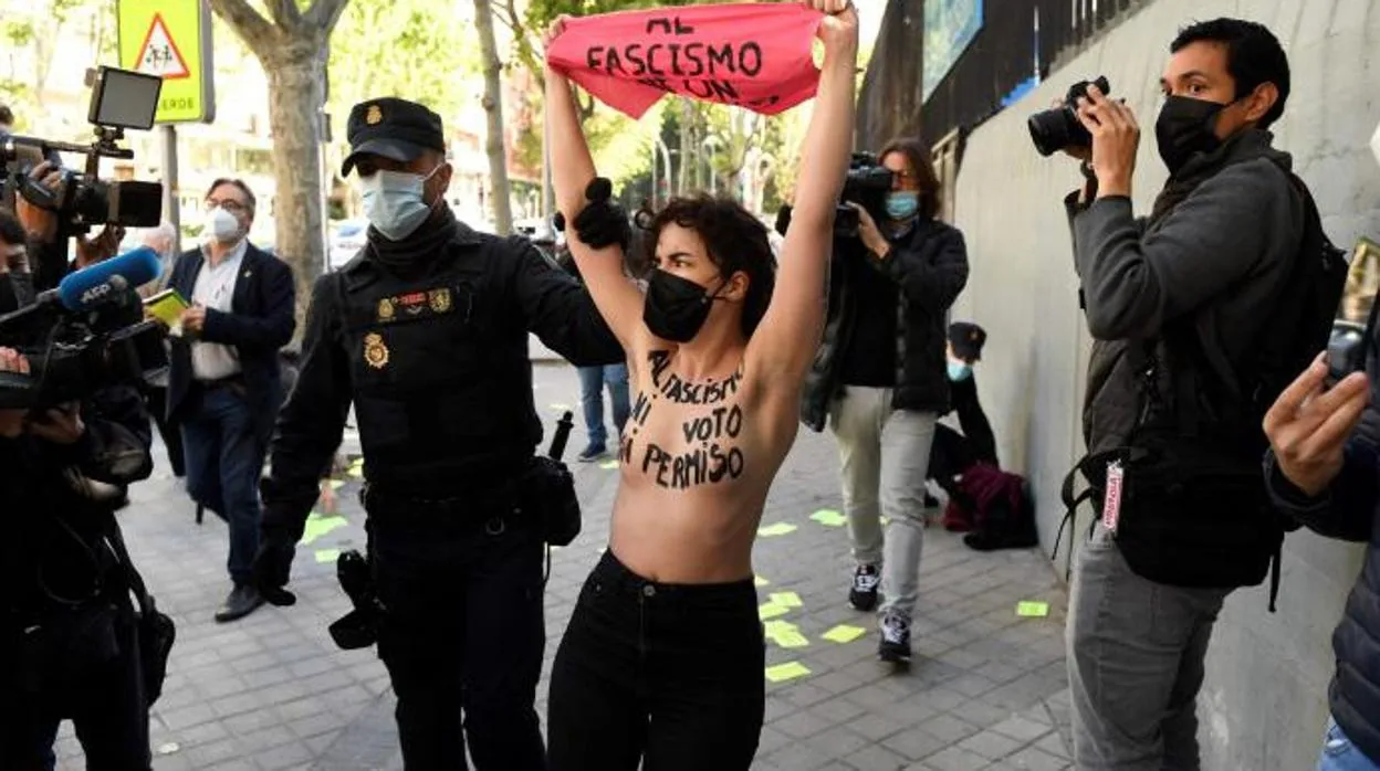 Un grupo de activistas de Femen protesta con el torso desnudo en el colegio  electoral de Rocío Monasterio