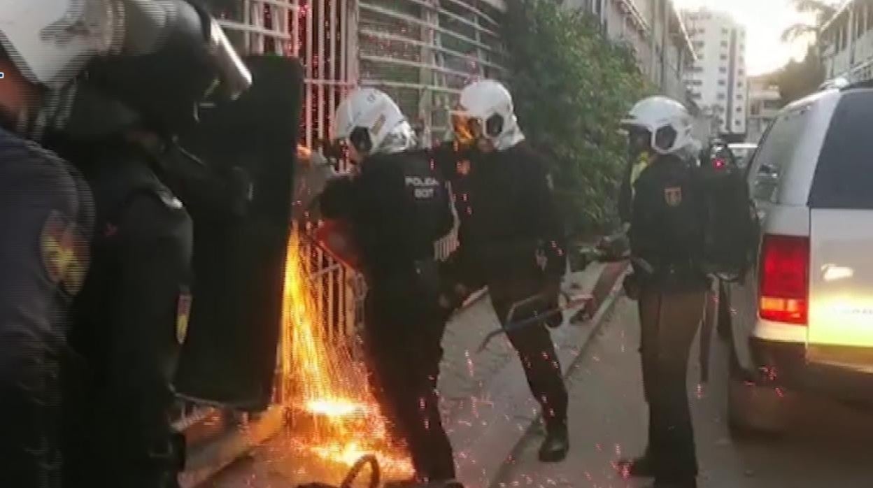 Agentes fuerzan una puerta con una radial para acceder a uno de los narcopisos