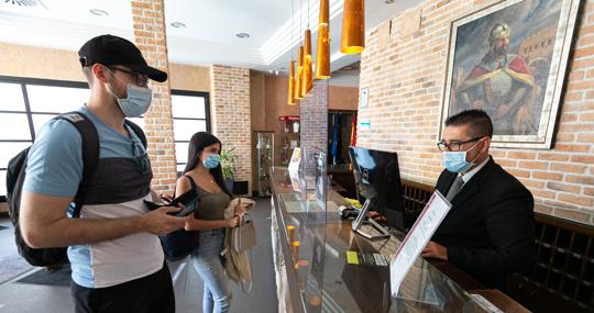 Dos jóvenes realizan el check in en uno de los hoteles del Casco Histórico