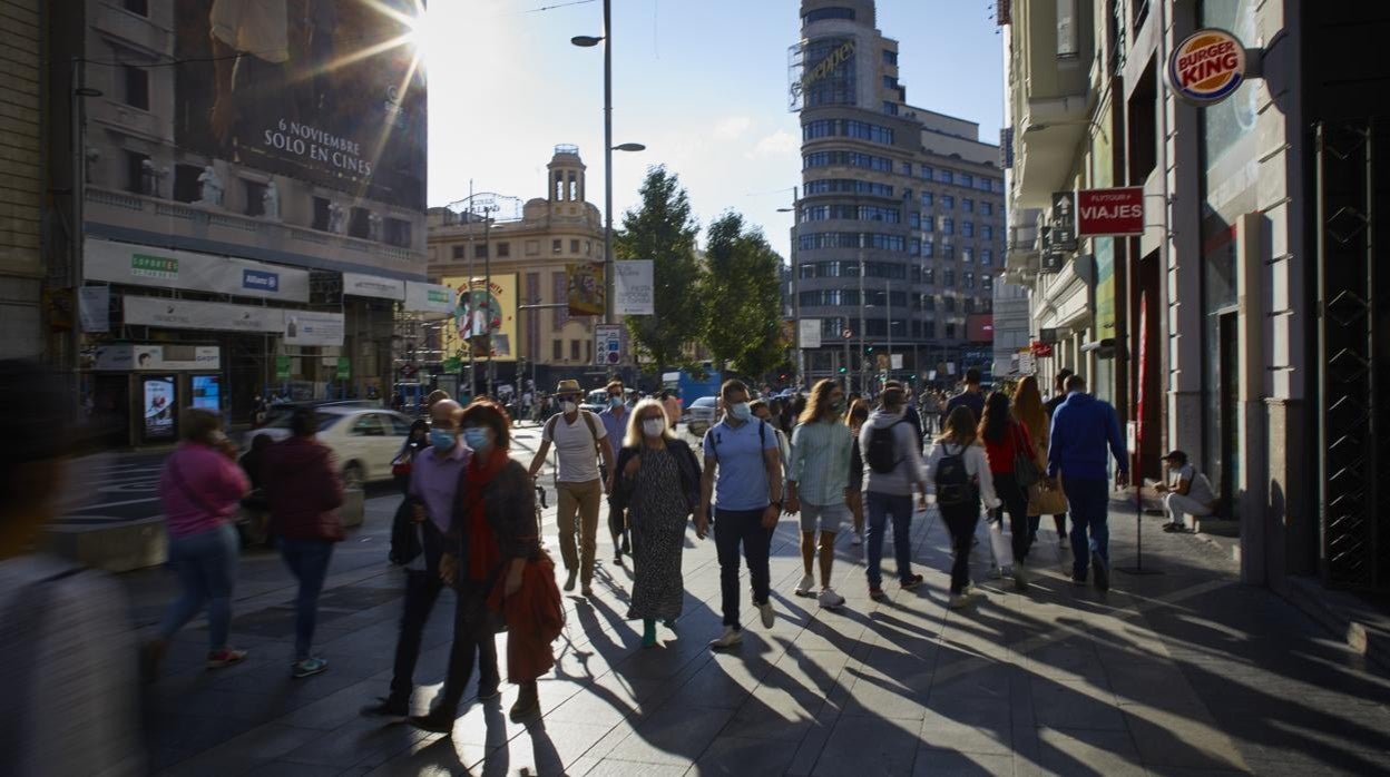 Madrileños y turistas pasean por la Gran Vía