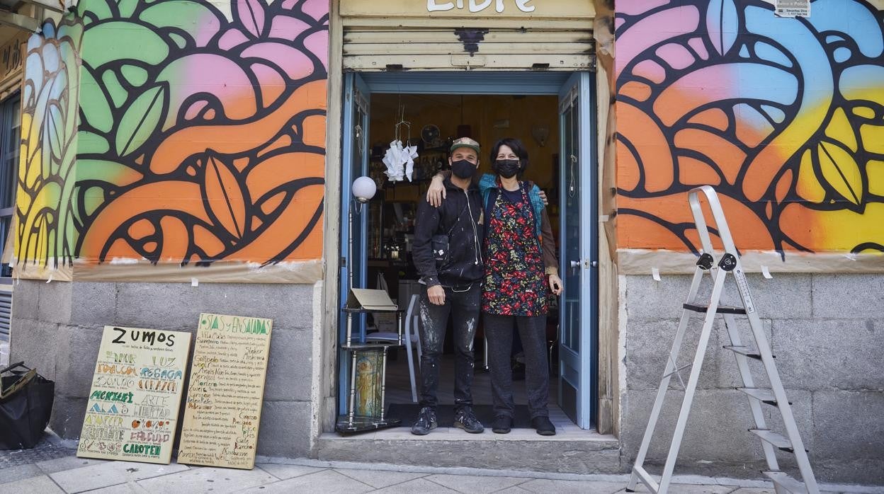 La artista Dirty pinta la fachada del Café La Libra, regentado por Pilar Catanio, en Lavapiés.