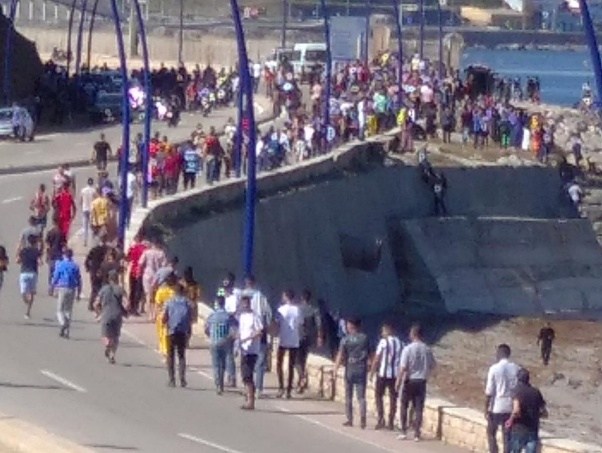 Una hilera de inmigrantes retorna a Castillejos tras el fracaso de su asalto. 