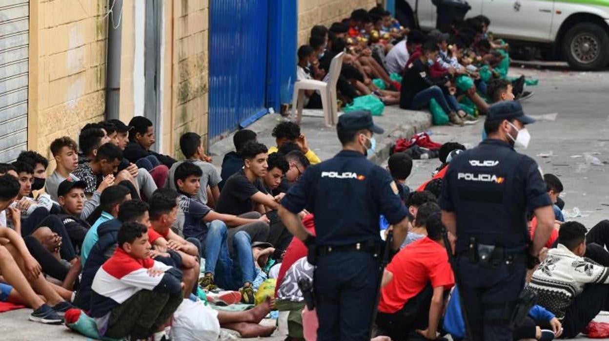 Dos policías nacionales con un grupo de menas en Ceuta esta semana