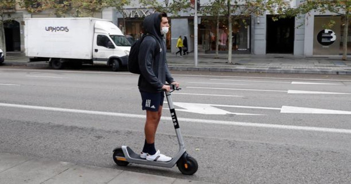 Un joven circula en patinete por una de las vías principales de Madrid