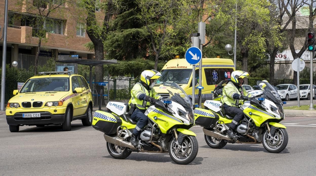 Dos agentes de la Policía Municipal escoltan a una ambulancia