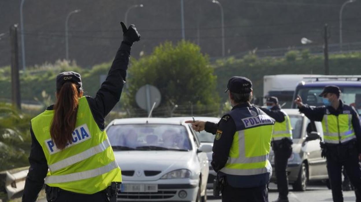 Varios agentes de Policía Nacional dan el alto a un vehículo en un control de movilidad