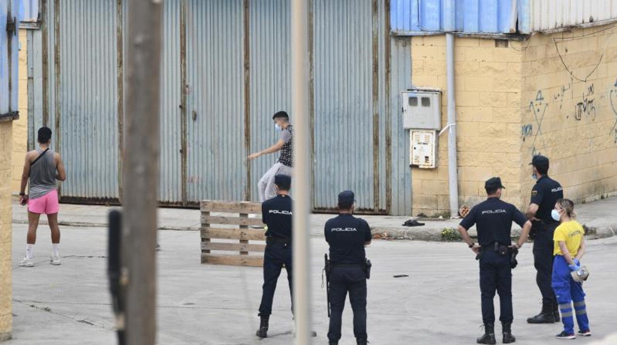 Agentes de la Policía Nacional vigilan a varios menores no acompañados en uno de los albergues improvisados en Ceuta tras la llegada masiva de inmigrantes en mayo