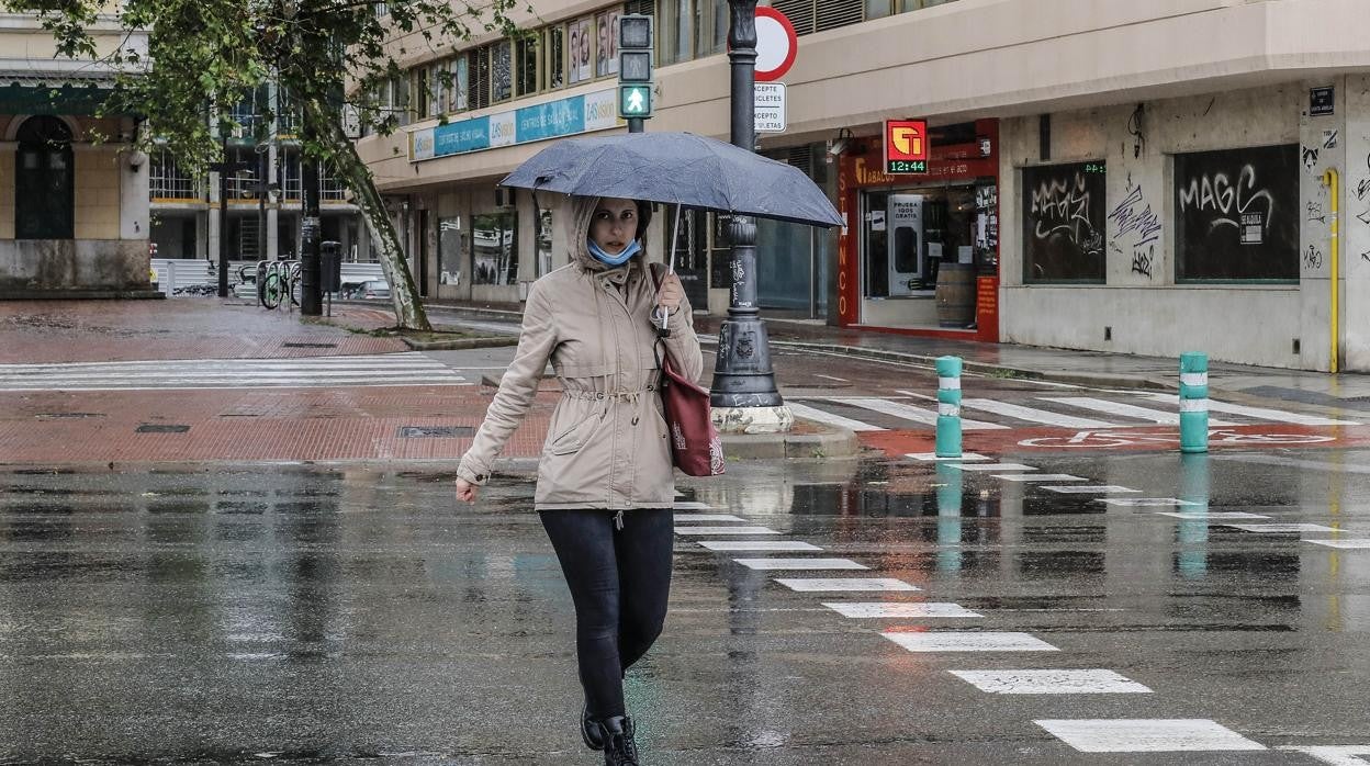 Imagen de archivo de una mujer con un paraguas en Valencia