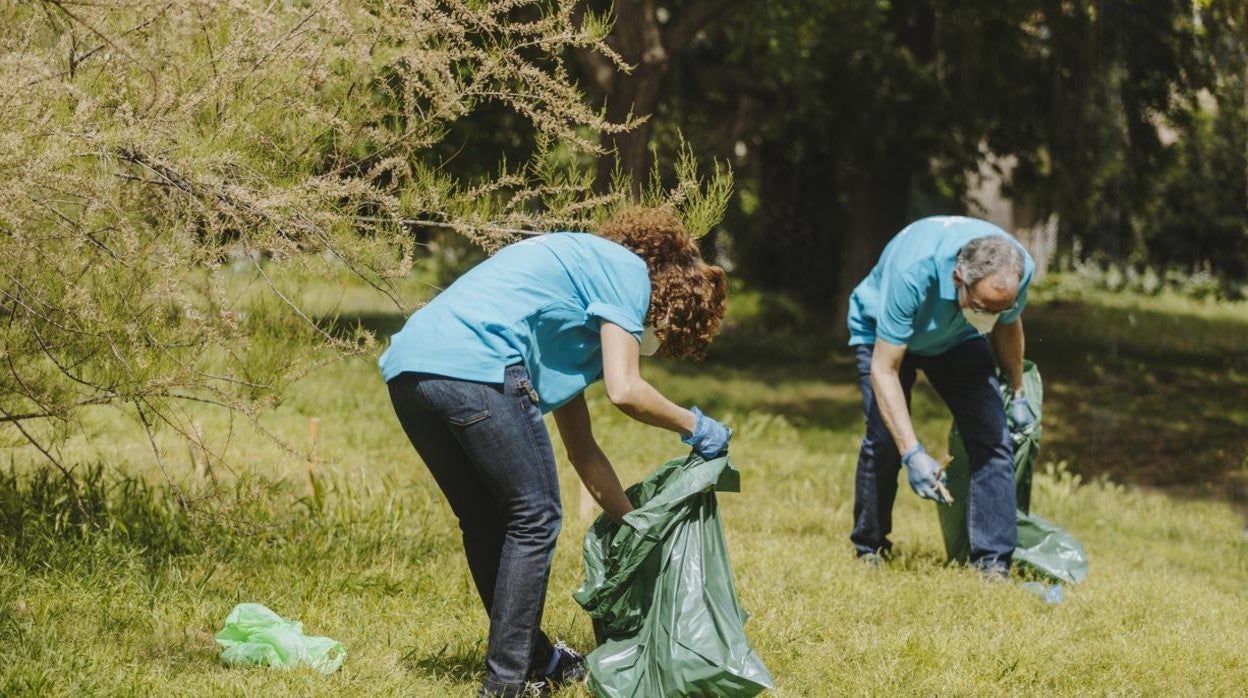 Dos voluntarios de Caixabank recogiendo residuos