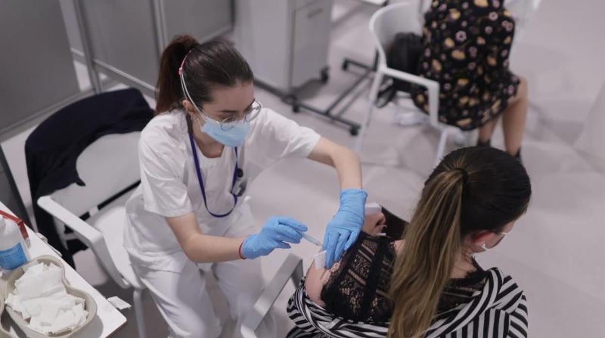 Una enfermera administra una dosis de vacuna a una ciudadana en el Hospital Isabel Zendal