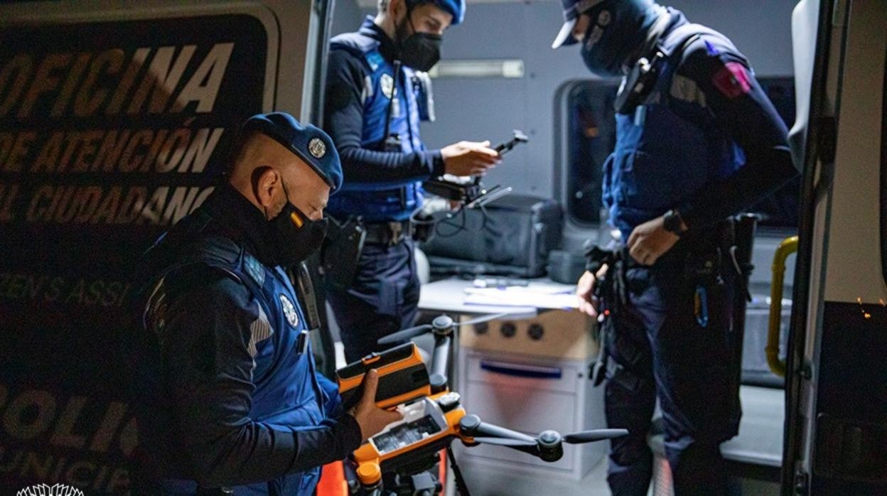 Tres agentes de la Policía Municipal configuran un dron antes de que 'patrulle' Madrid