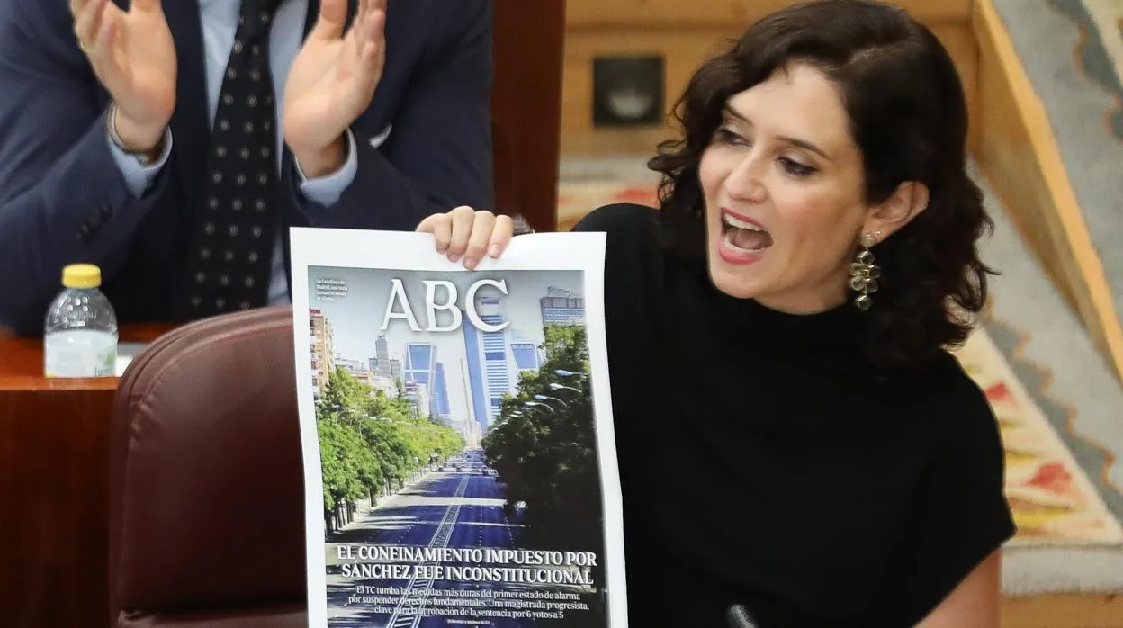 Isabel Díaz Ayuso sujeta una portada de ABC, durante una intervención en la Asamblea
