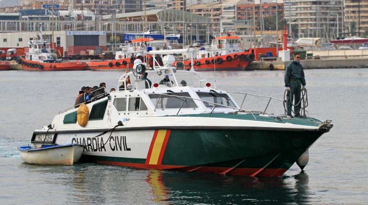 Una patrullera de la Guardia Civil remolca una patera en Alicante