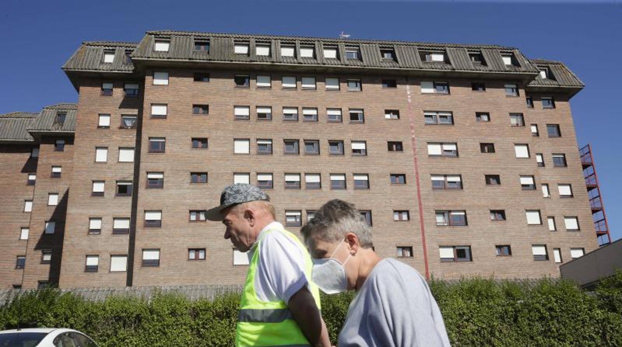 Dos personas mayores caminan ante una residencia de Lugo