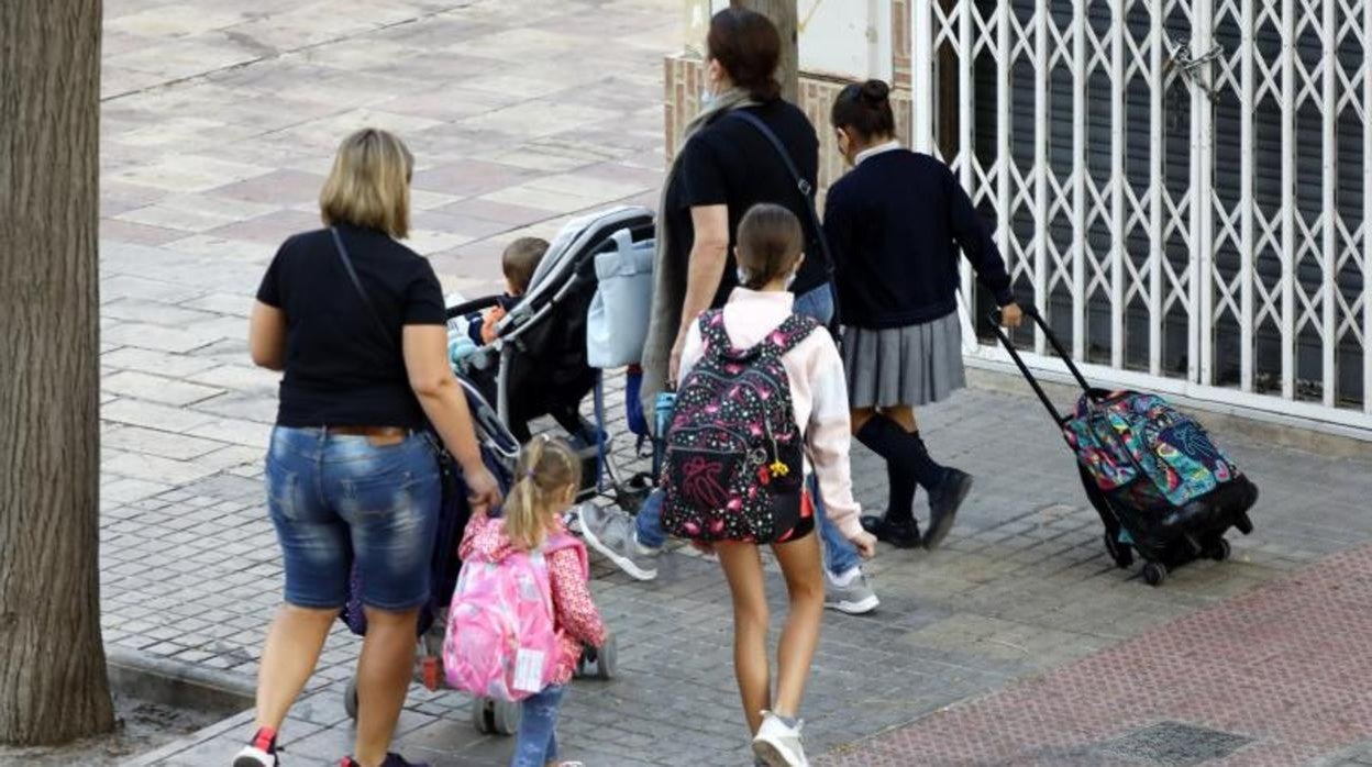 Familias con escolares camino a un colegio de Alicante, durante la pandemia