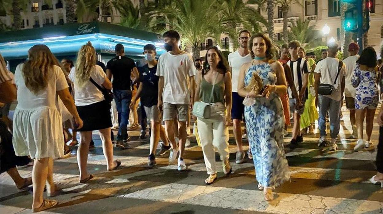 Turistas y paseantes por la Explanada de Alicante, de noche durante la pandemia
