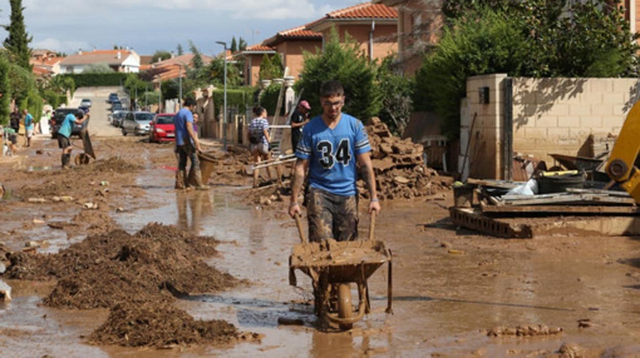 Vecinos de Cobisa sacan con carretillas el lodo de sus viviendas
