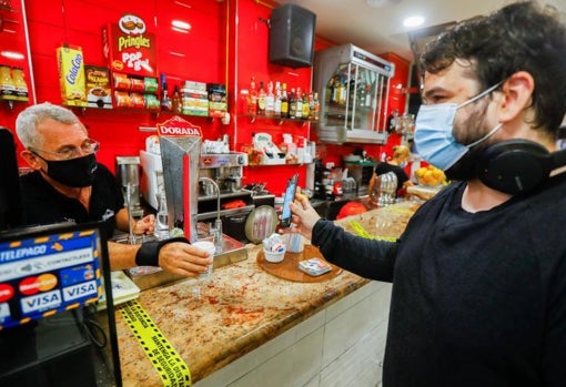 Un cliente muestra el certificado Covid en un bar de Tenerife