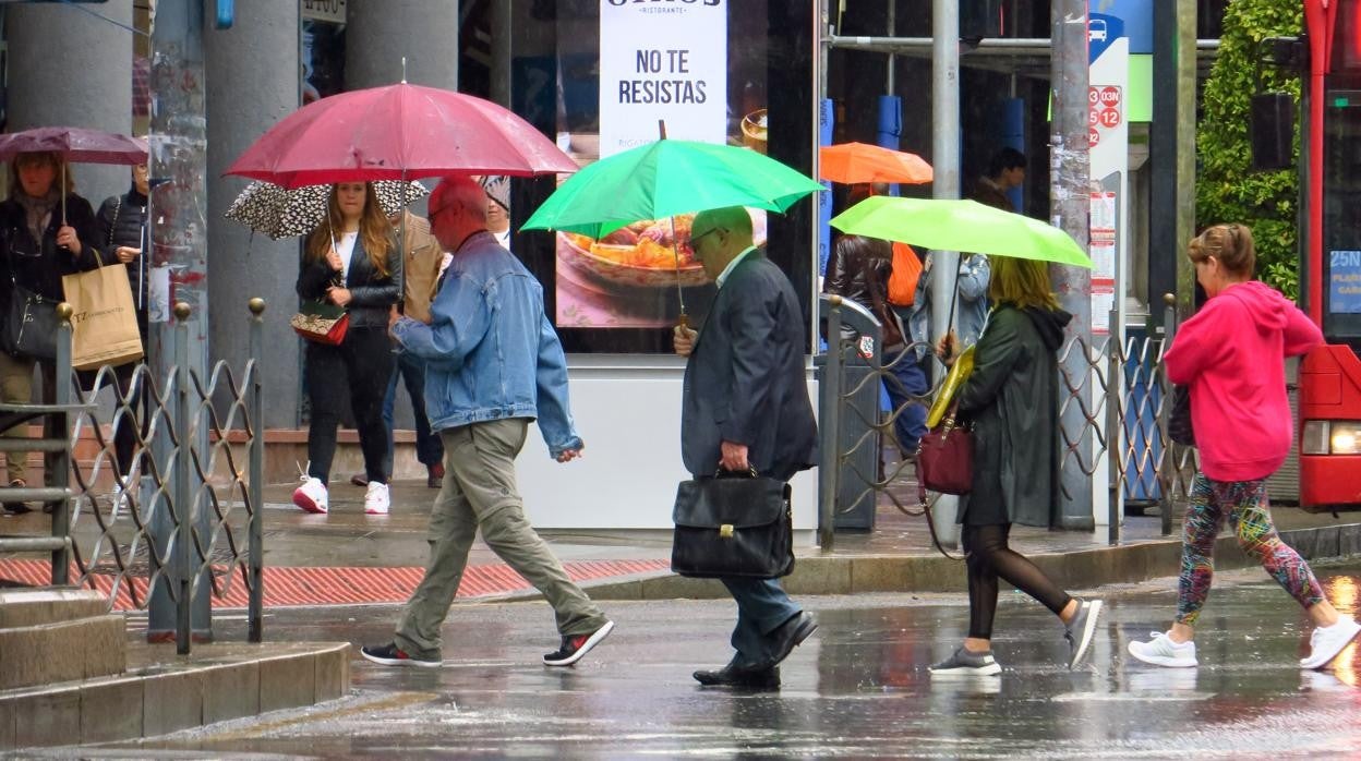 Imagen de archivo de unas personas paseando bajo la lluvia