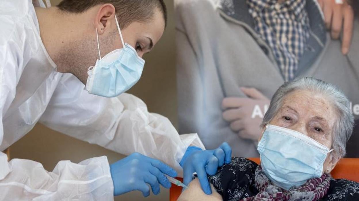 Un sanitario vacuna a una residente madrileña a principios de enero de este año