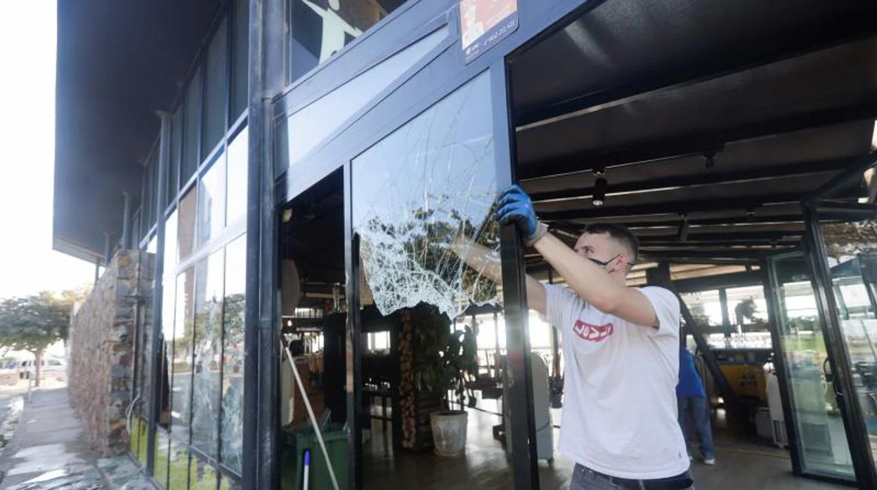 Operarios retirando cristales rotos de un restaurante en la zona de Bogatell