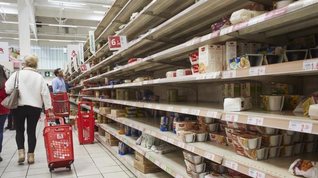 Varios ciudadanos hacen la compra en un supermercado madrileño