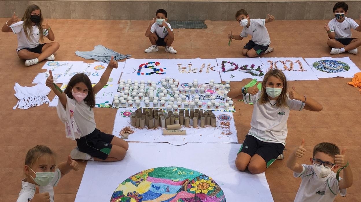 Un grupo de alumnos junto a unos murales confeccionados en el colegio ELIS