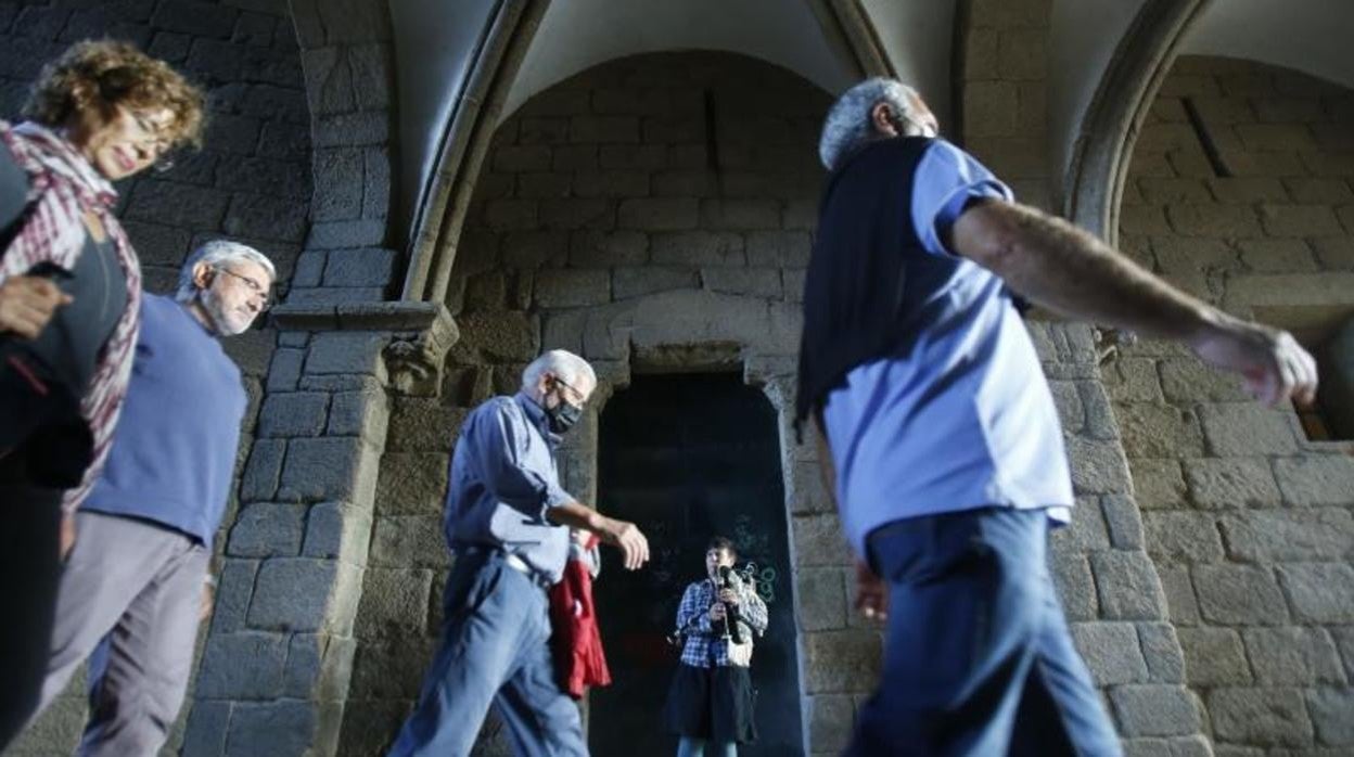 Un grupo de turistas pasa ante una gaiteira en Santiago