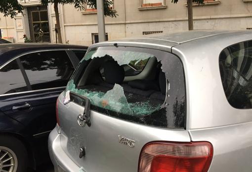 La luna trasera, reventada, de uno de los coches afectados por los altercados de ayer