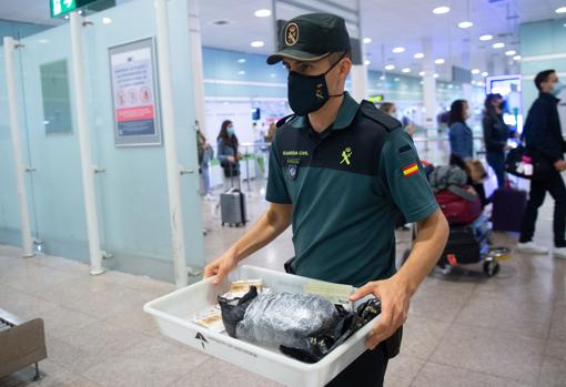 Un guardia civil lleva una caja con pertenencias de un viajero