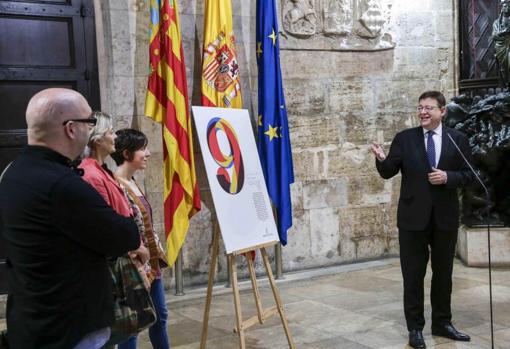 Ximo Puig junto a un cartel de celebracón del 9 d'Octubre