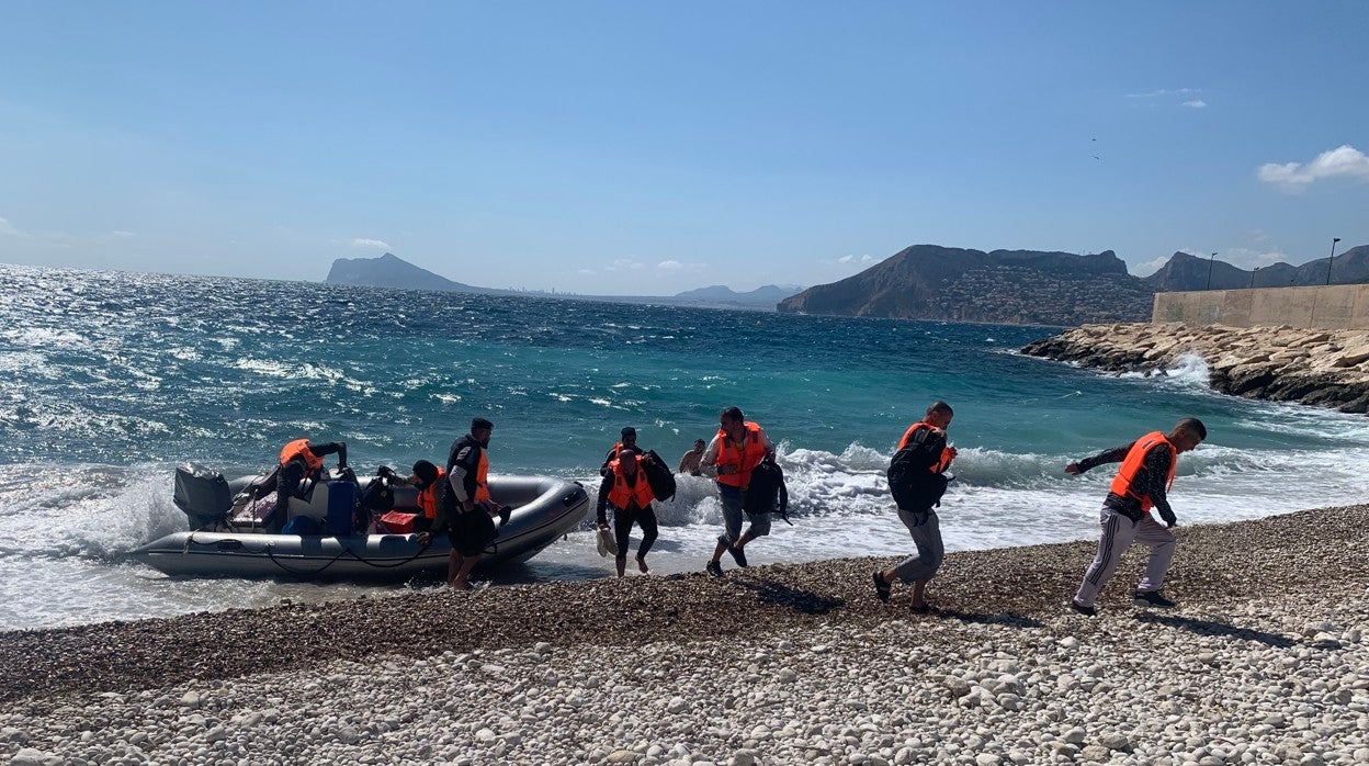 Llegada de una lancha neumática a una playa de Calpe con ocho hombres y una mujer