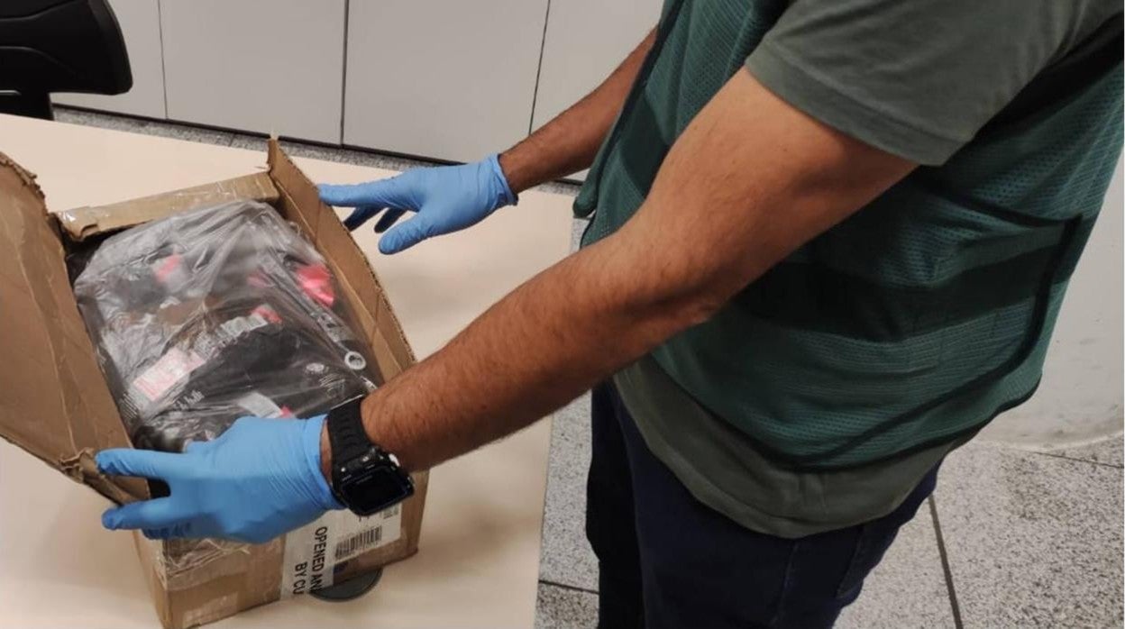 Un investigador de la Guardia Civil muestra la droga intervennida a la pareja en el aeropuerto alicantino